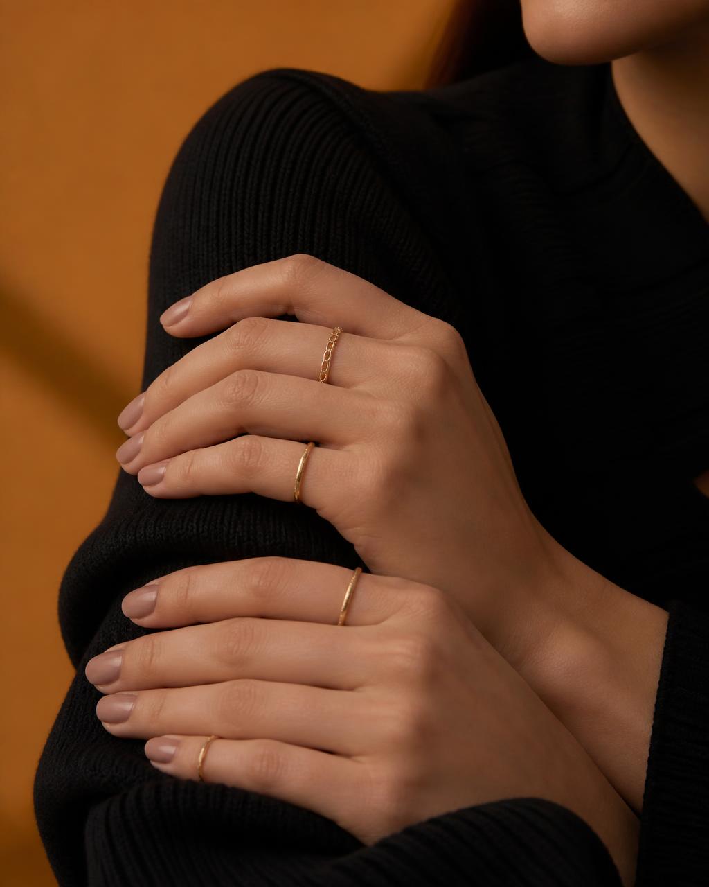 Close-up of hands wearing delicate gold rings